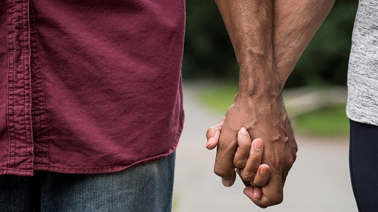 Dvaja ľudia držiaci sa za ruky