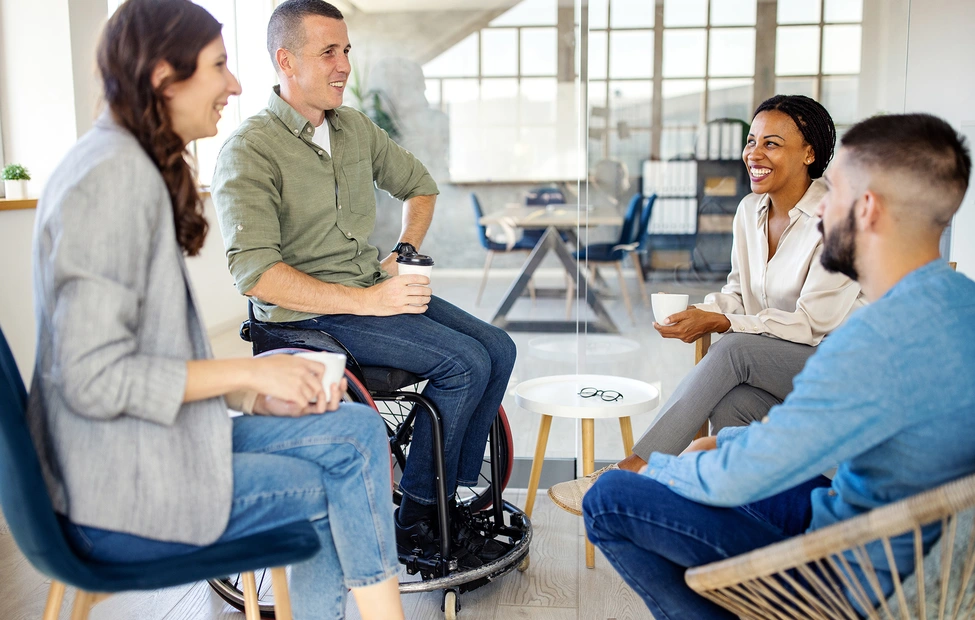 Group of four business people discussing and laughing