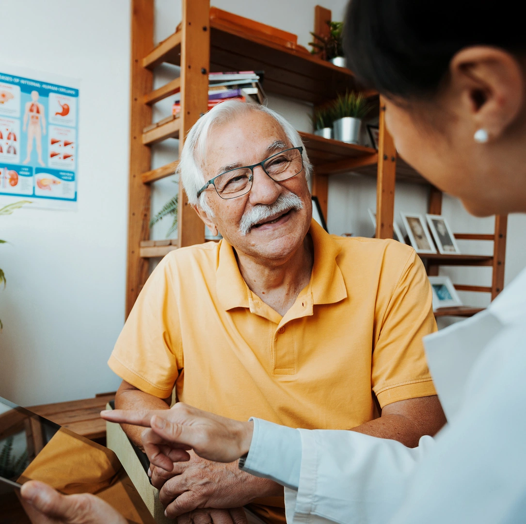 A healthcare professional and senior patient in a conversation using a tablet