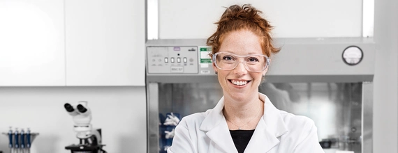 Portrait d'une jeune scientifique souriante dans un laboratoire de Novartis