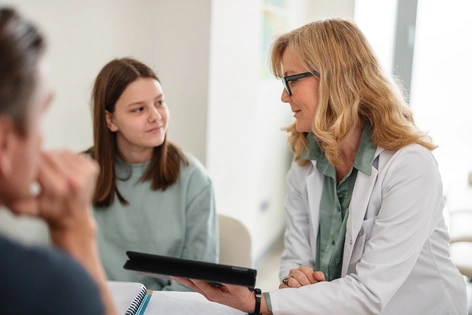Paciente joven conversando con doctora