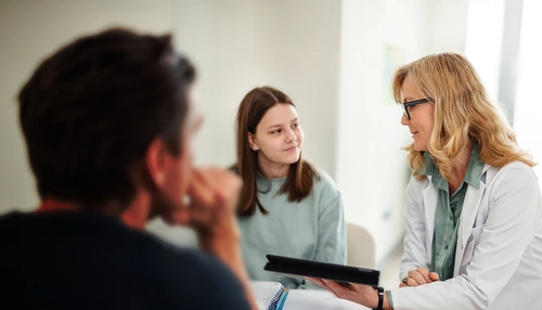 Pediatrician talking with a young teenager in the office