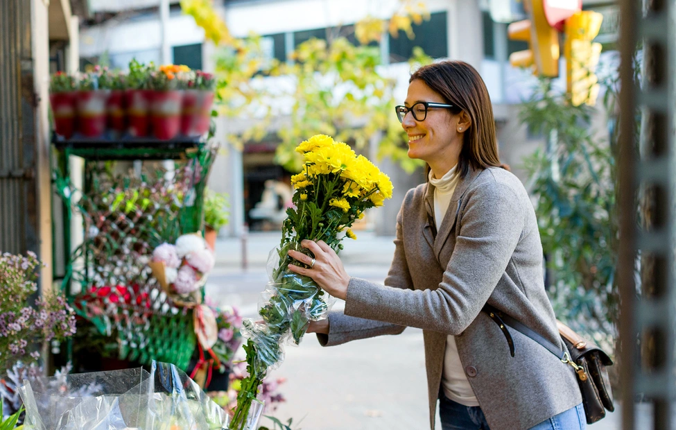 Lady buying yellow flowers in a store
